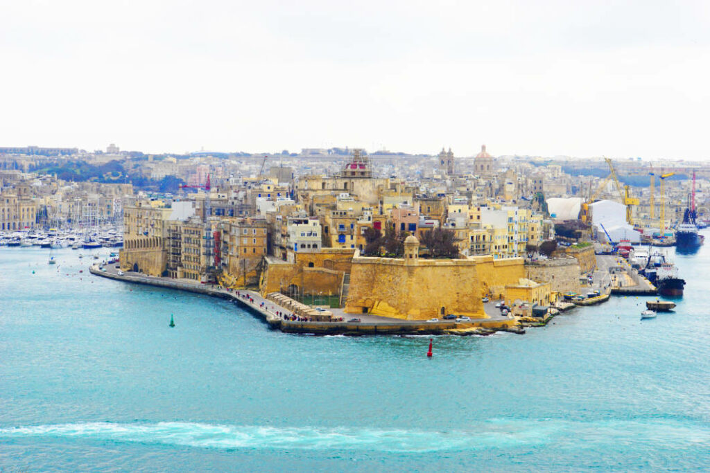 Blick von oben auf die historische, befestigte Halbinsel Senglea im Grand Harbour von Valletta, Malta, mit ihren charakteristischen Kalksteingebäuden und der markanten Gardjola-Warte am Ende der Bastion.