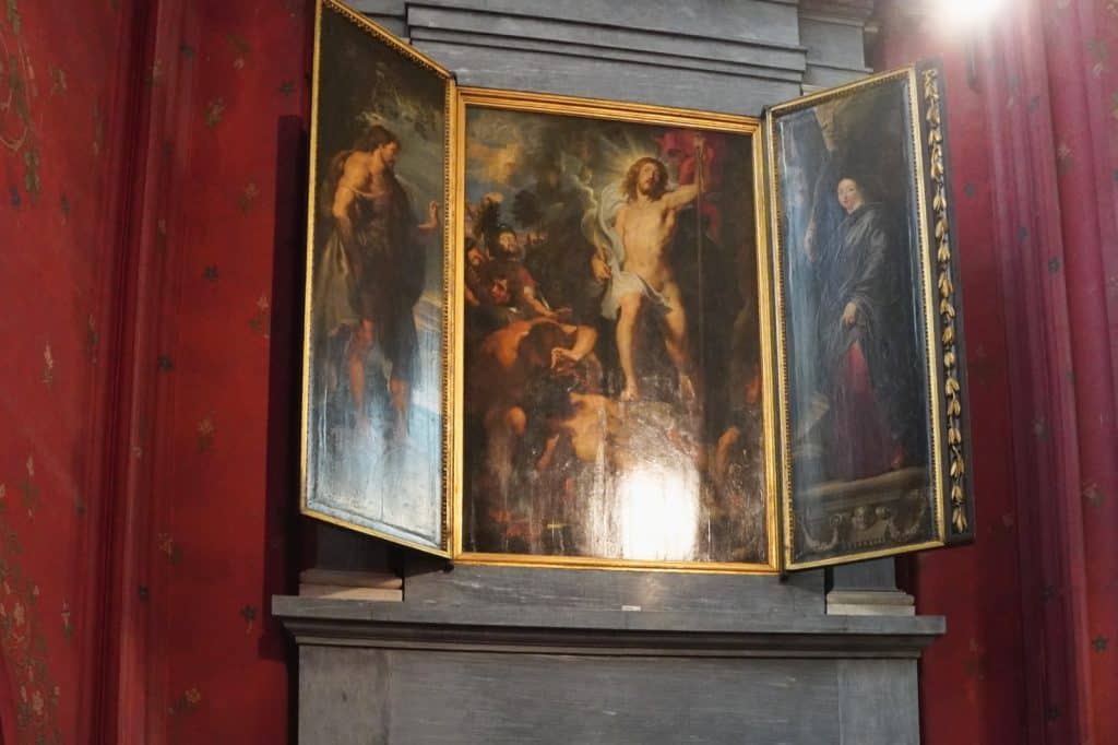 Ein barockes Triptychon in der Liebfrauenkathedrale zeigt im Mittelfeld die Auferstehung Christi, flankiert von zwei schmaleren Seitenflügeln mit Heiligenfiguren vor einer roten Wand.