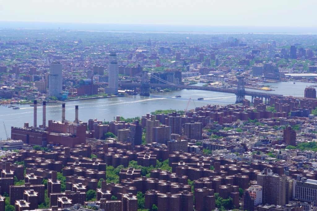 Vogelperspektive von der Aussichtsplattform des Empire State Building auf den East River, die Williamsburg Bridge und die dichte Backsteinbebauung der Lower East Side in New York City.