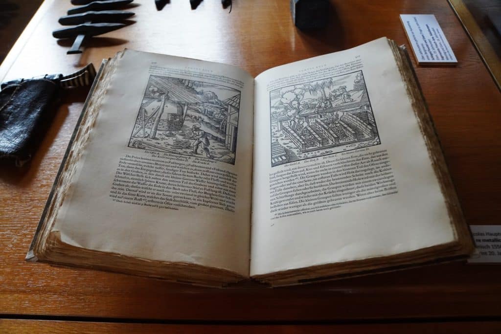 Ein aufgeschlagenes Exemplar von Georgius Agricolas Werk „De re metallica“ liegt in einer Vitrine im Schloss Glauchau in Sachsen und zeigt historische Holzschnitte zum Bergbau.