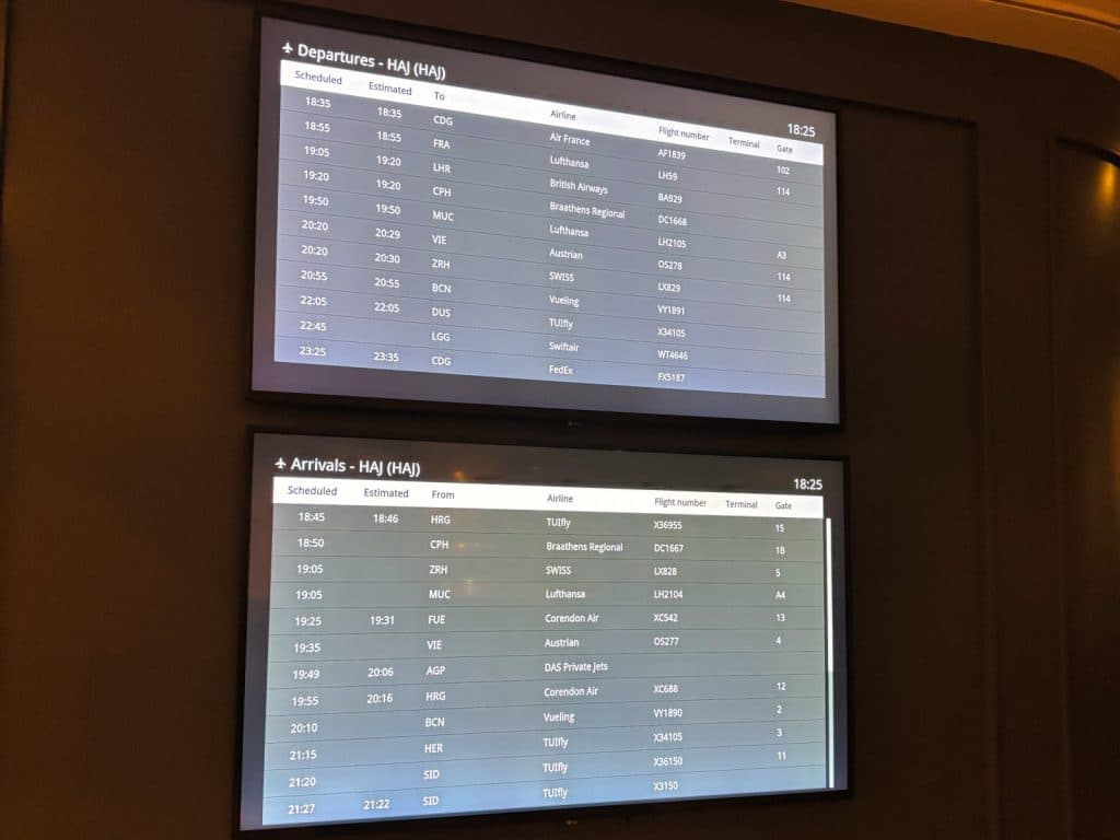 Zwei digitale Bildschirme im Maritim Hotel Hannover zeigen aktuelle Fluginformationen für Abflüge und Ankünfte am Flughafen Hannover (HAJ) in tabellarischer Form an.
