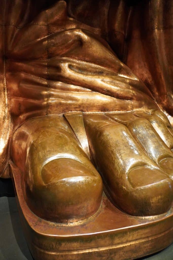 Nahaufnahme einer kupferfarbenen Replik des Fußes der Freiheitsstatue im Museum auf Liberty Island, die die monumentalen Zehen und die Struktur der Metallplatten zeigt.