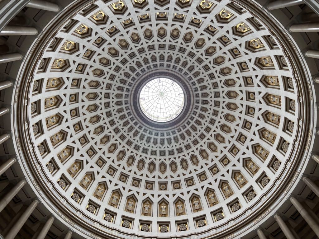 Blick direkt nach oben in die reich verzierte Kuppel der Befreiungshalle in Kelheim, die durch ein zentrales Oberlicht beleuchtet wird und mit konzentrischen Reihen aus geometrischen Kassetten und goldenen Ornamenten gestaltet ist.