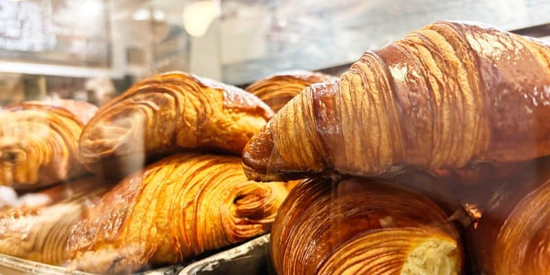 Frisch gebackene, goldbraun glänzende Croissants und Pain au Chocolat liegen in der Auslage einer Bäckerei in Montreal.