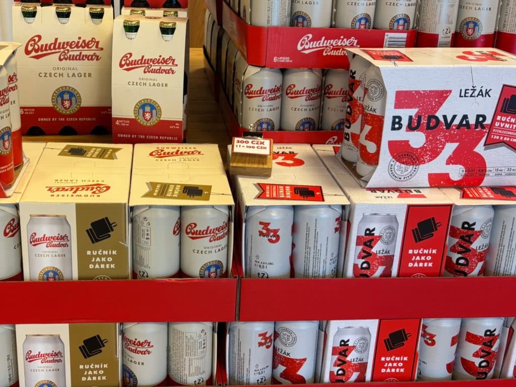 Regale im Shop der Budweiser Brauerei sind mit verschiedenen Packungen und Dosen von Budweiser Budvar Original Czech Lager und Budvar 33 Ležák gefüllt.