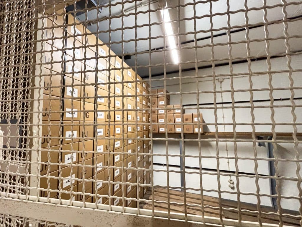 Hinter einem Metallgitter stapeln sich zahlreiche nummerierte braune Lagerboxen in einem Raum des Bundesbank-Bunkers in Cochem, in denen früher die Ersatzwährung gelagert wurde.