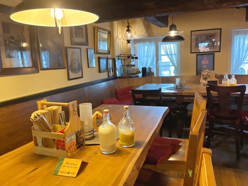 Menüsafari in Soest: Rustikale Gaststube eines Brauhauses in Soest mit Holztischen, gemütlichen Sitzbänken und historischen Bildern an den Wänden.