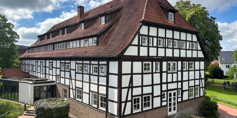 Ein großes, historisches Fachwerkhaus mit rotem Ziegeldach und weißer Fassade, das als Hotel Schnitterhof in Bad Sassendorf dient, umgeben von einer gepflegten Gartenanlage.