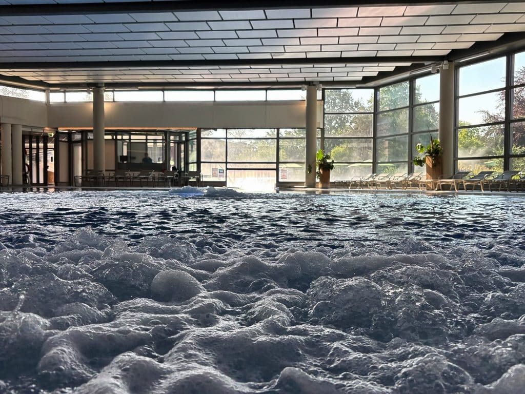 Blick aus der Froschperspektive über das sprudelnde Wasser eines Innenpools in der Therme Bad Sassendorf