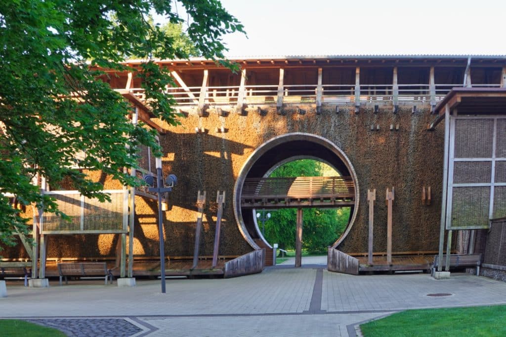 Ein kreisförmiger Durchgang führt durch das mit Schwarzdornreisig gefüllte Gradierwerk im Kurpark von Bad Sassendorf, über dem eine hölzerne Aussichtsplattform verläuft.