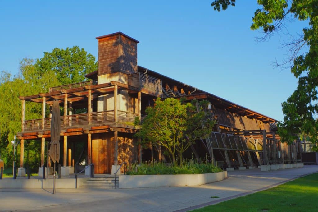 Das hölzerne Gradierwerk im Kurpark von Bad Sassendorf präsentiert sich in der Abendsonne mit einer markanten Turmkonstruktion und weitläufigen, überdachten Wandelgängen.