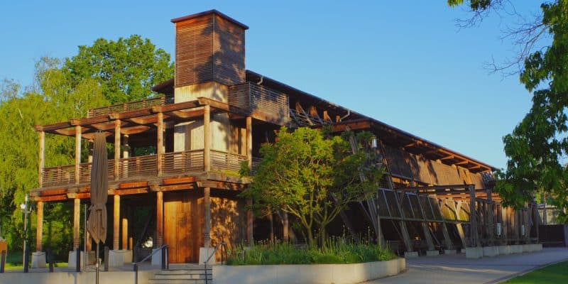 Das hölzerne Gradierwerk im Kurpark von Bad Sassendorf präsentiert sich in der Abendsonne mit einer markanten Turmkonstruktion und weitläufigen, überdachten Wandelgängen.