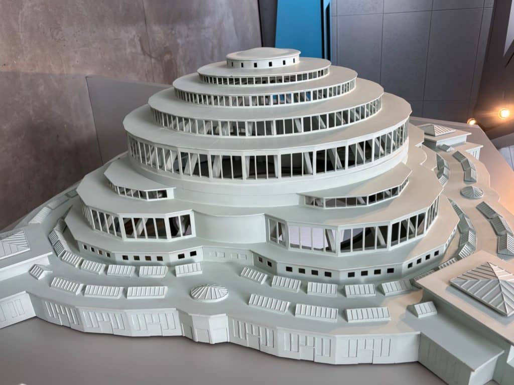 Ein detailliertes, weißes Architekturmodell der Breslauer Jahrhunderthalle im Besucherzentrum zeigt die markante, abgestufte Kuppelstruktur mit ihren Fensterreihen und den umliegenden Anbauten.