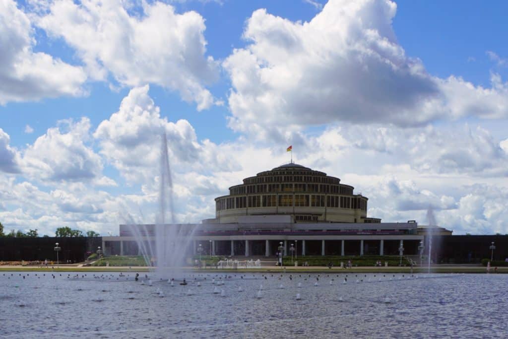 Die historische Jahrhunderthalle in Breslau mit ihrer markanten Kuppel hinter einem großen Wasserbecken