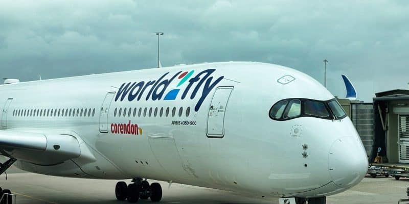 Nahaufnahme eines Airbus A350-900 von World2Fly mit Corendon-Logo auf dem Rollfeld, bereit für den Flug nach Curacao. Das Flugzeug wird von Bodenpersonal und Servicefahrzeugen unter einem bewölkten Himmel abgefertigt.