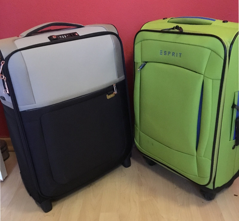 Handgepäck auf Flugreisen: Zwei Koffer stehen nebeneinander auf einem Holzboden. Die Koffer sind typische Handgepäck-Koffer, die für Reisen geeignet sind.